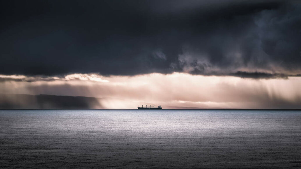 Ship in ocean with dark clouds